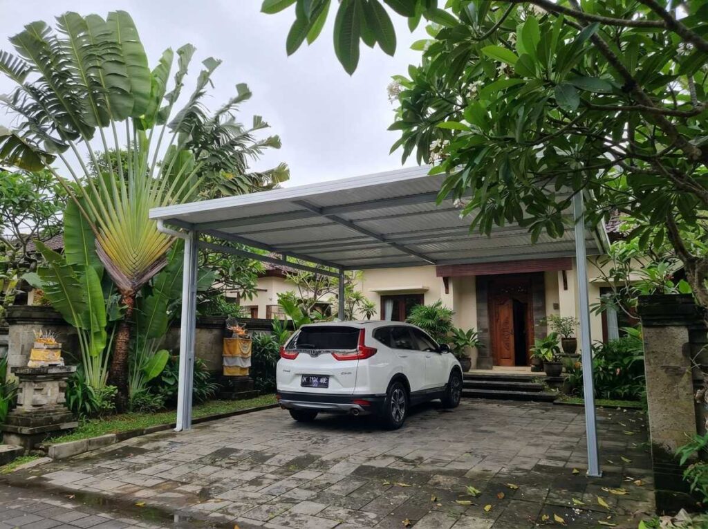 Penerapan teknologi isolasi panas kanopi UPVC berkualitas tinggi dari balikanopi untuk meredam suhu panas carport perumahan tropis di Bali.